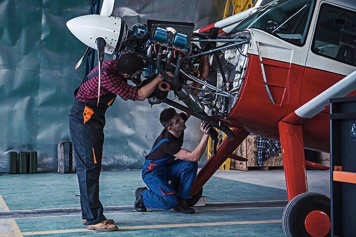 Aeronautical mechanics working on a single-engine plane