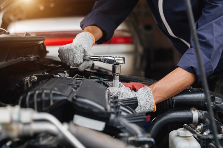 Automotive mechanic working on car engine