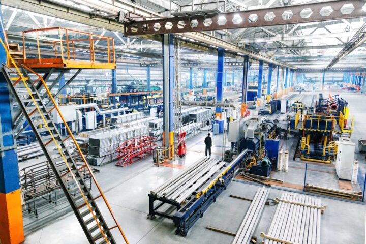 Manufacturing plant with heavy-duty equipment and workers operating the equipment
