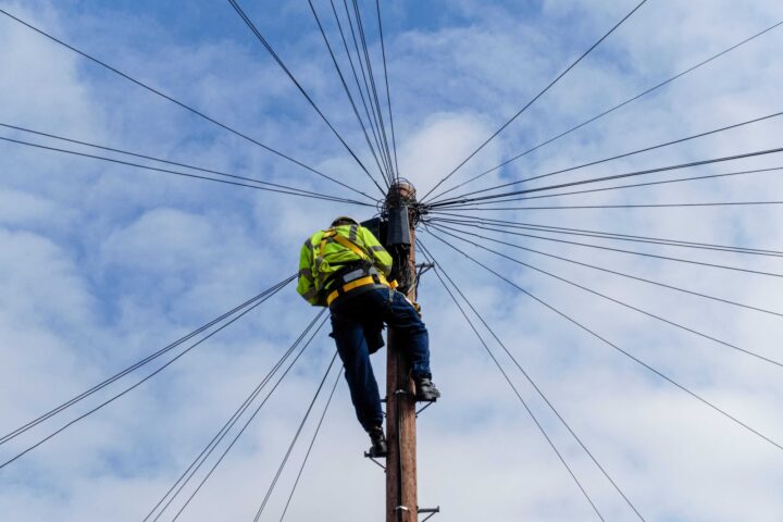 Power lineman working on communication cables on power line