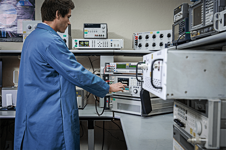 Probata employee in blue lab coat running test on calibration equipment