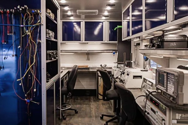 Inside look of Probata Mobile Calibration Unit with equipment, desks, and chairs
