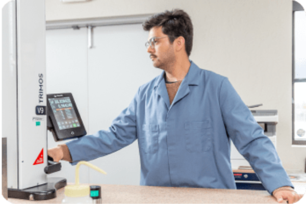 Probata employee in blue lab coat looking at equipment metrics