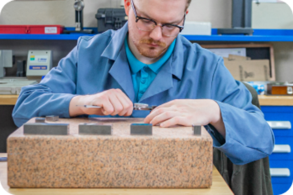 Close up of Probata employee in blue lab coat focusing on measurements of equipment