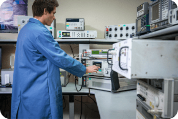 probata employee in a blue lab coat operating testing equipment